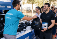Entrega de una bolsa del corredor personalizada antes de una carrera popular