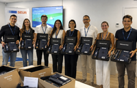 Grupo de nuevos empleados mostrando sus Welcome Packs durante una jornada de bienvenida en la empresa. Grupo de nuevos empleados mostrando sus Welcome Packs durante una jornada de bienvenida en la empresa.