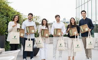Empleados utilizando sets ecológicos personalizados con productos sostenibles en una empresa moderna.